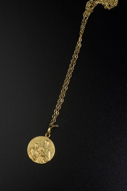 Chaine en or jaune 18K retenant une médaille...