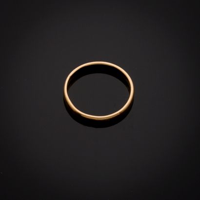 Alliance en or jaune 18k (gravée). 
Doigt...