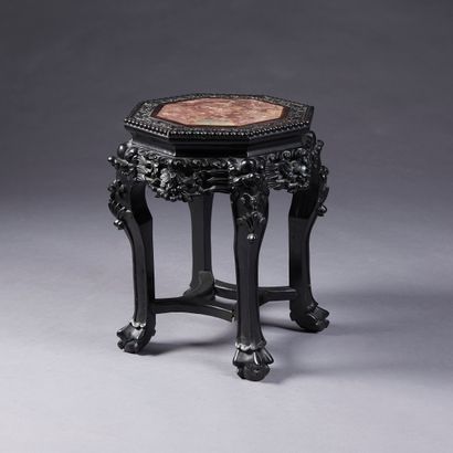 Octagonal low pedestal in richly carved wood...