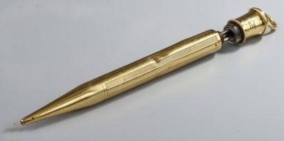 PORTE-MINE en or jaune strié 18K (chocs).
Signé...