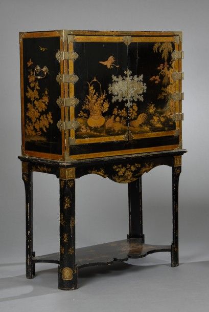 Cabinet en laque or sur fond noir. Il ouvre...
