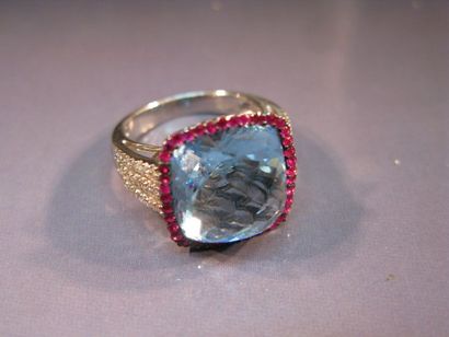 Bague en or gris centrée d'une topaze bleue...