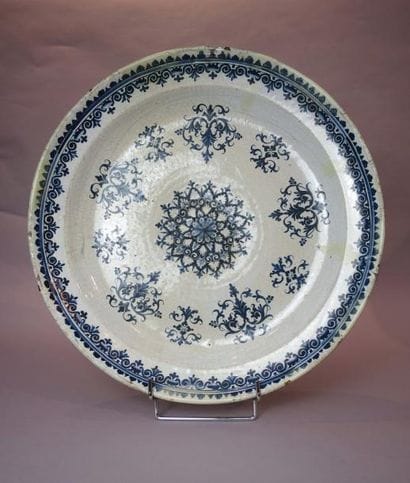 *Grand plat en faïence blanche à décor en...