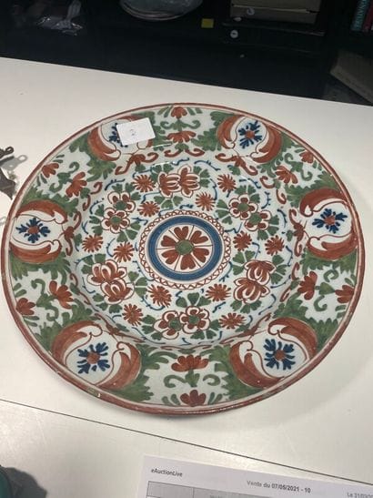 Plat creux en faïence à décor polychrome.

D...