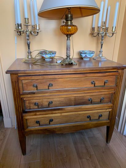 Une petite commode en noyer ouvrant à trois...