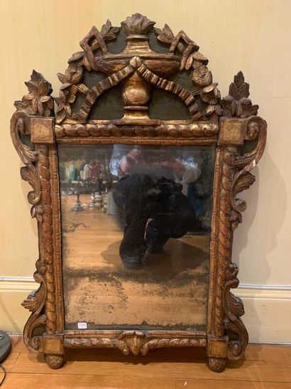 Un miroir en bois doré à décor de guirlandes...