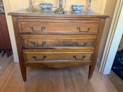 Une petite commode en noyer ouvrant à trois...