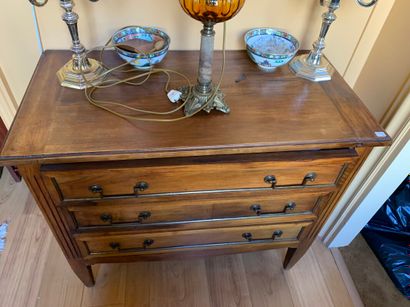 Une petite commode en noyer ouvrant à trois...