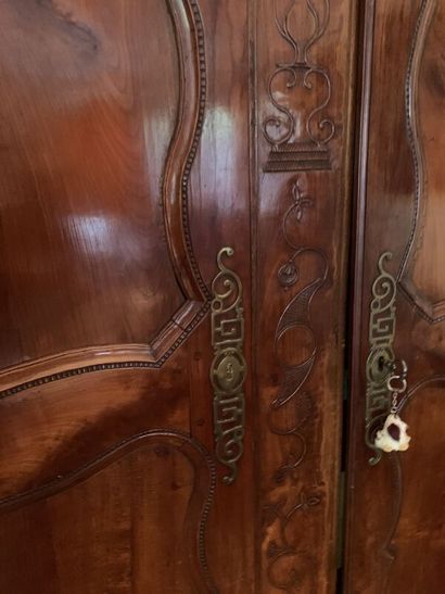 Carved wood cabinet opening with two doors,...