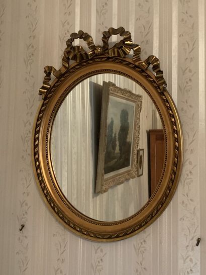 Gilded wood oval mirror with ribbon decoration,...