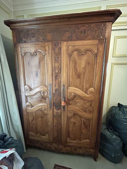 Walnut cabinet, molded and carved with flowers,...