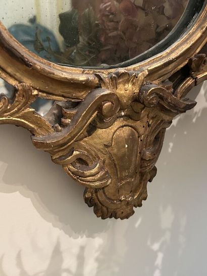 Gilded wood mirror in the shape of an escutcheon,...