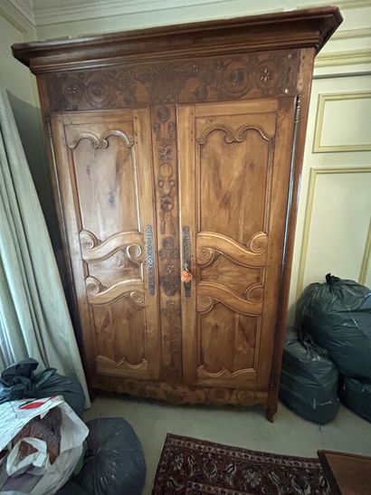 Walnut cabinet, molded and carved with flowers,...