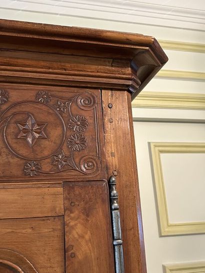 Walnut cabinet, molded and carved with flowers,...