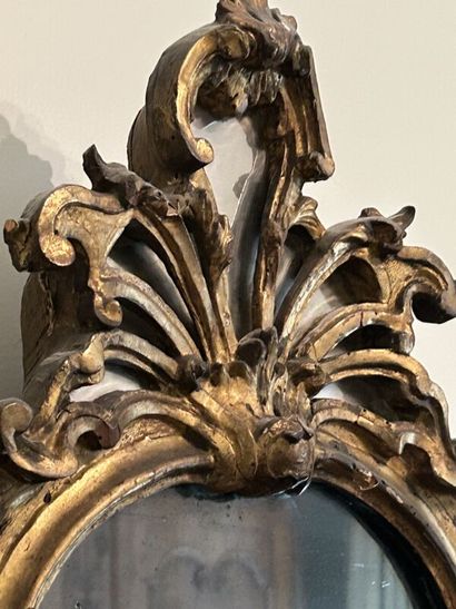 Gilded wood mirror in the shape of an escutcheon,...
