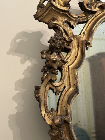 Gilded wood mirror in the shape of an escutcheon,...