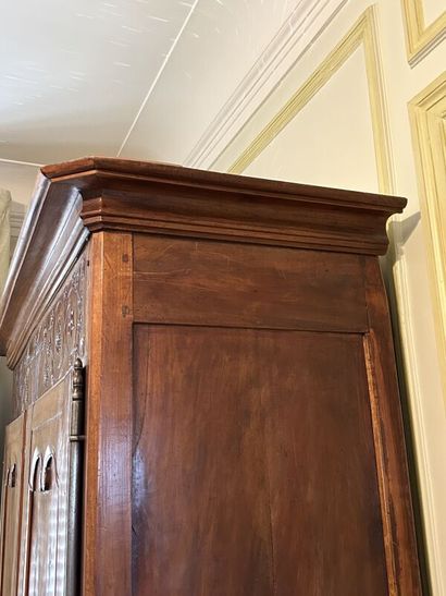 Walnut cabinet, molded and carved with flowers,...