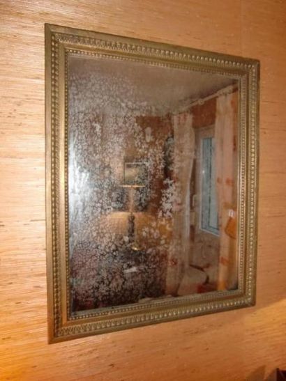 Miroir en bois et stuc doré à frise de perles.
40...