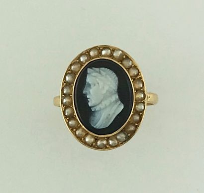 A gold ring with a cameo onyx profile of...