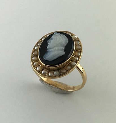 A gold ring with a cameo onyx profile of...