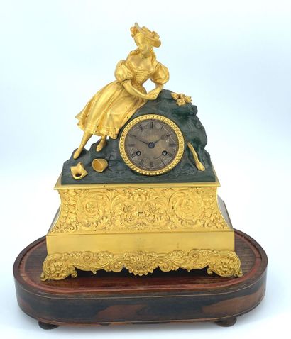PENDULE en bronze doré ornée d'une femme...