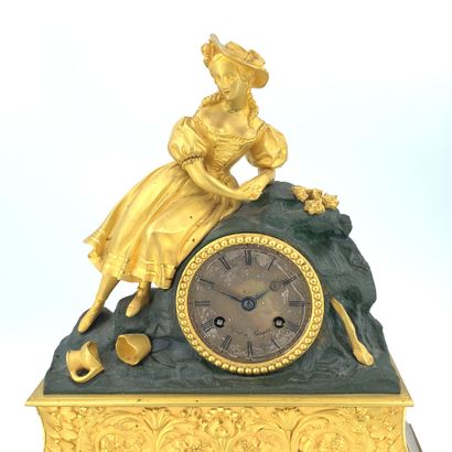 PENDULE en bronze doré ornée d'une femme...