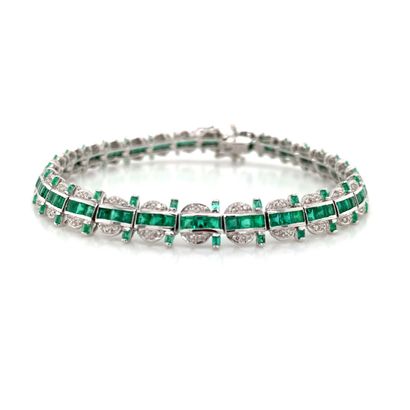 BRACELET en or gris, émeraudes et diamants...
