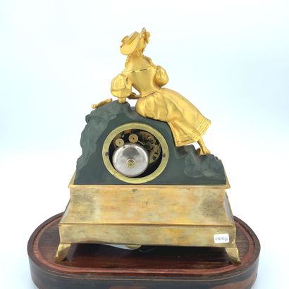 PENDULE en bronze doré ornée d'une femme...