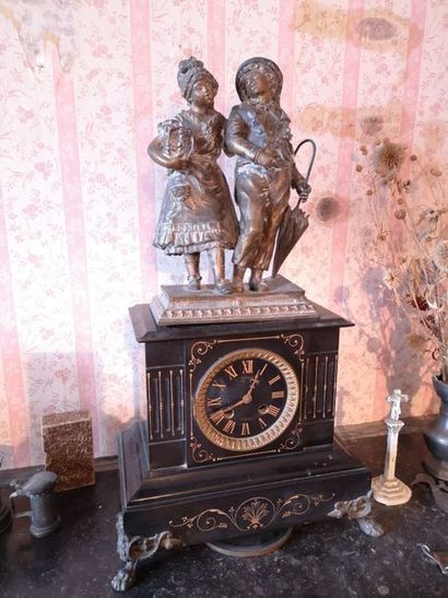 Black marble clock surmounted by a subject...