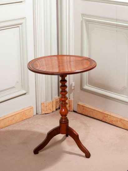 Tripod pedestal table in natural wood.

English...