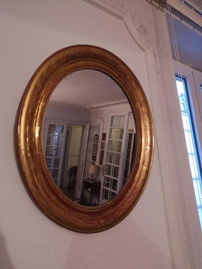 Miroir ovale en bois et stuc doré.