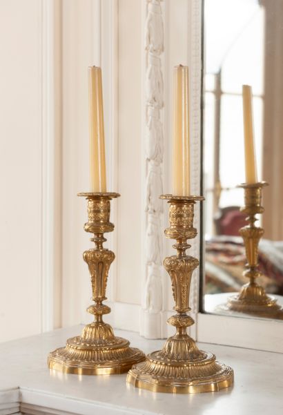 
A pair of ormolu candlesticks decorated...