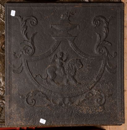 Cast iron fireback featuring a cherub riding...