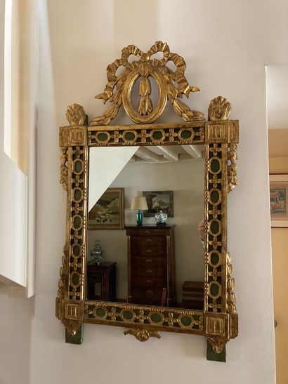 Carved and gilded wood mirror with ribbon...