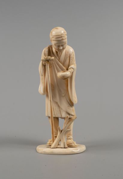 Okimono showing an old man leaning on a cane...