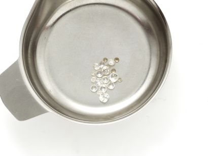 Lot de diamants et pierres blanches sur papier.
Poids...