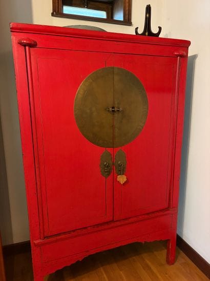 Red Chinese two-door cabinet, featuring three...