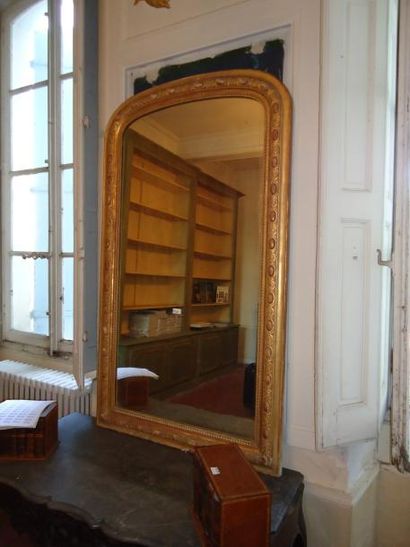 Grand miroir en bois doré cintré dans la...