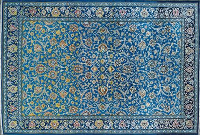TAPIS GHOUM à fond bleu à décor de fleurs...