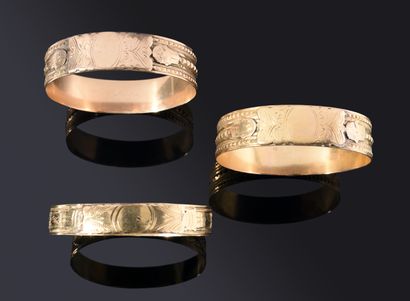 Three rigid BRACELETS, two of them wide,...