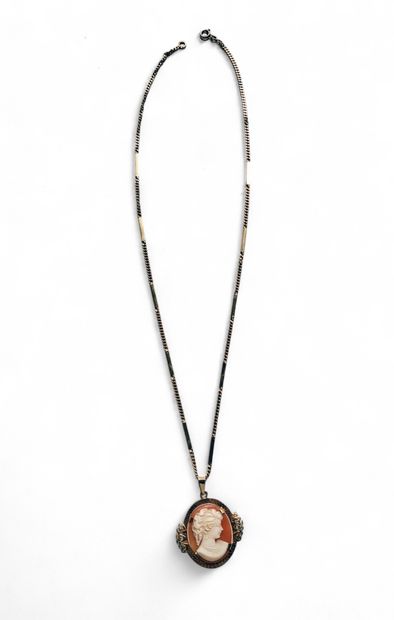 A gold chain and pendant decorated with a...