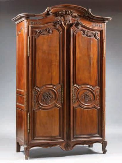 ARMOIRE EN NOYER mouluré et sculpté de bouquets,...