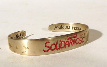 Bracelet en métal avec l’inscription en rouge...