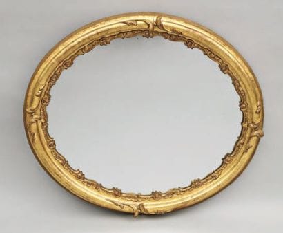 MIROIR OVALE en bois doré et stuc, à décor...