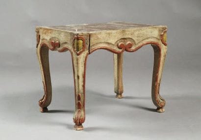 TABLE BASSE en bois rechampi à décor de volutes....