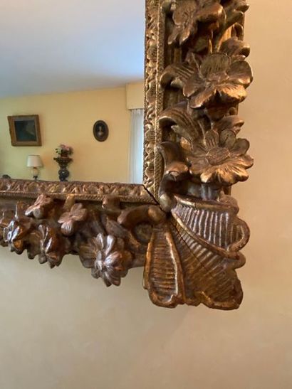 Miroir en bois et stuc doré à décor de fleurettes
Style...