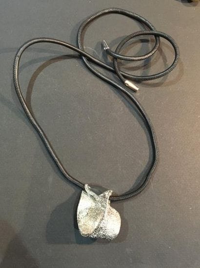 BALENCIAGA. Cordon cuir rehaussé d'un pendentif...