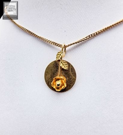 Médaille à décor de fleurs et sa chaine
Or...