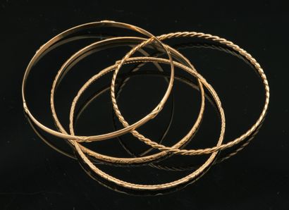 Quatre bracelets en or jaune 18K 750 millièmes,...
