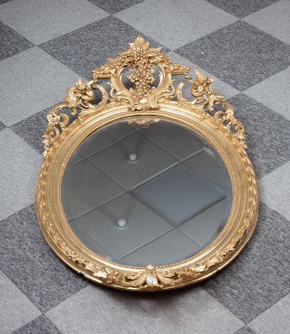 Important miroir oval en bois et stuc doré...
